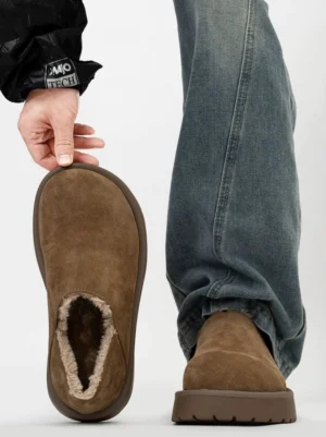 Rear bottom view of chestnut shearling-lined platform slip clogs showing the rounded closed toe, exposed shearling collar, matching brown sole, and textured grip outsole