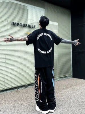 Black CHOIZE oversized streetwear T-shirt shown from the back with circular racing-inspired graphic print, loose crew neck silhouette, and contrast side seam details