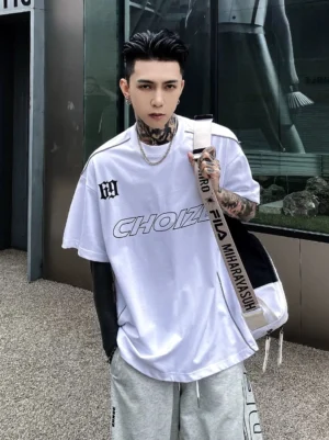 White CHOIZE oversized streetwear T-shirt shown from the front with bold motorsport graphic lettering, chest badge, contrast shoulder piping, and relaxed crew neck fit