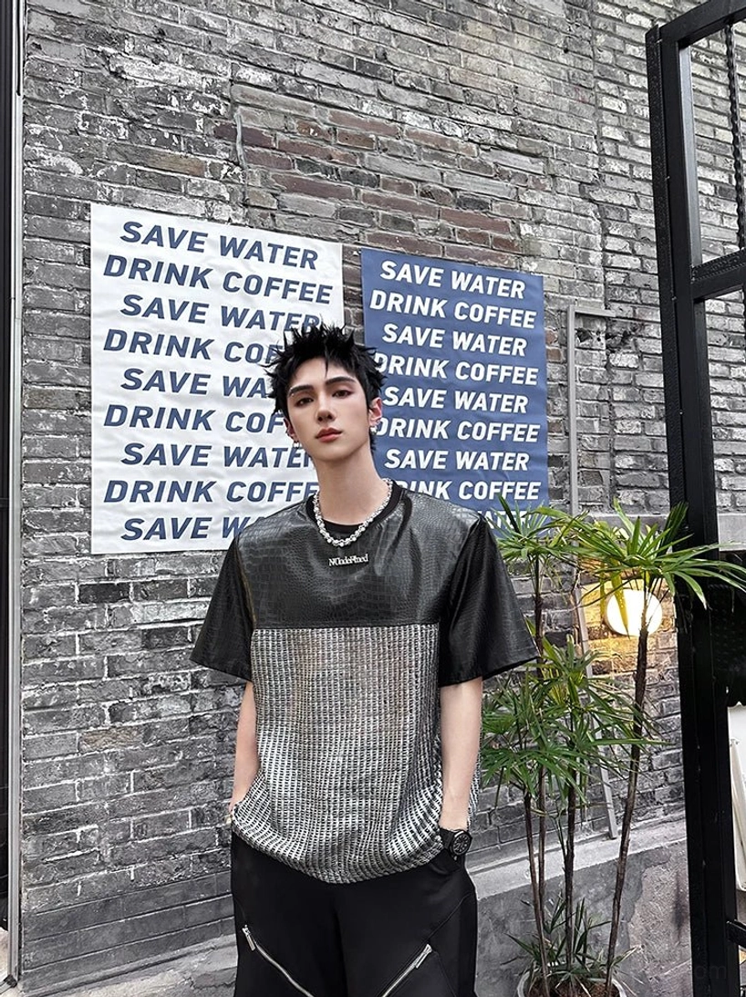 Front view of a black and silver chrome grid patchwork T-shirt featuring crocodile-effect sleeves, textured metallic torso, and relaxed Korean streetwear styling