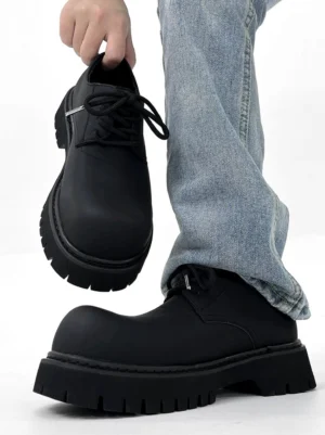 Front view of a chunky black matte platform derby shoe with smooth upper rounded toe and oversized streetwear sole