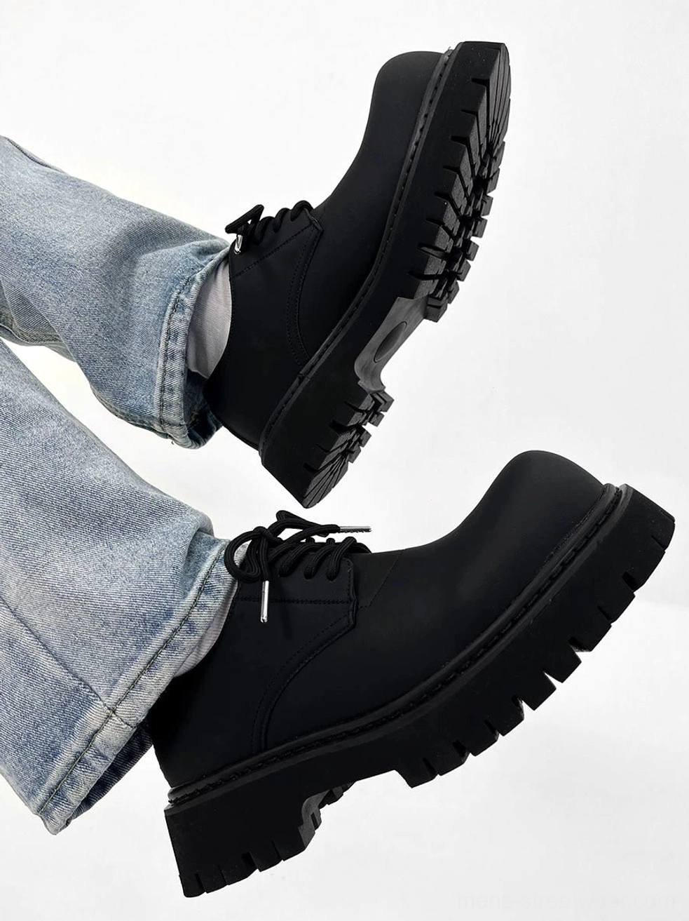 Bottom-up view of chunky black platform derby shoes with thick matte sole and classic lace-up construction
