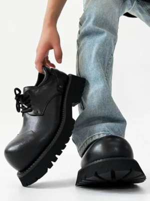 Chunky black platform derby shoes with rounded toe and lace-up front styled with light blue washed jeans