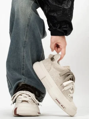 Chunky low-top platform casual sneakers shown from the side and rear on foot with relaxed denim styling and padded streetwear silhouette