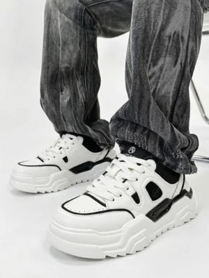 Model wearing black and white platform sneakers styled with vintage gray washed jeans worn on-foot ground level perspective showcase