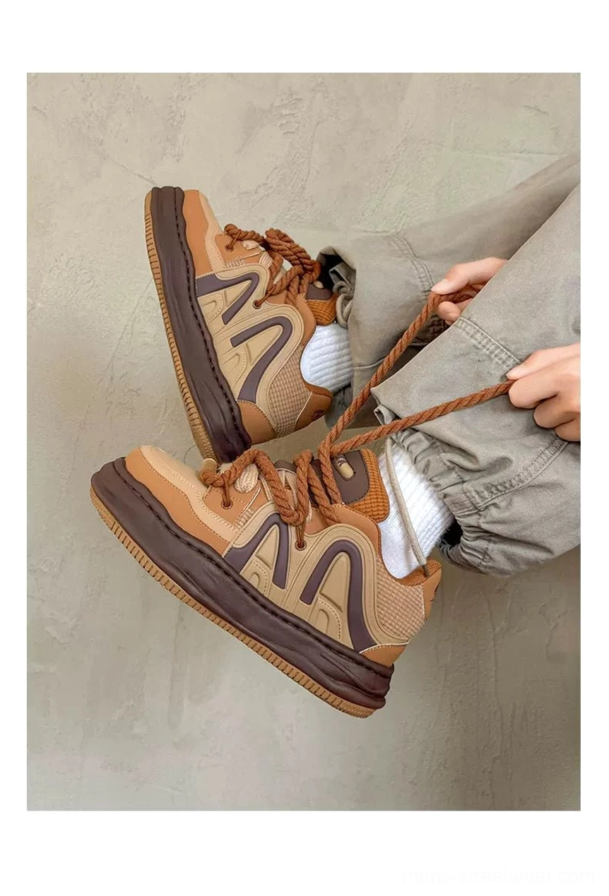 Caramel and dark brown rope lace platform sneakers worn with relaxed gray trousers