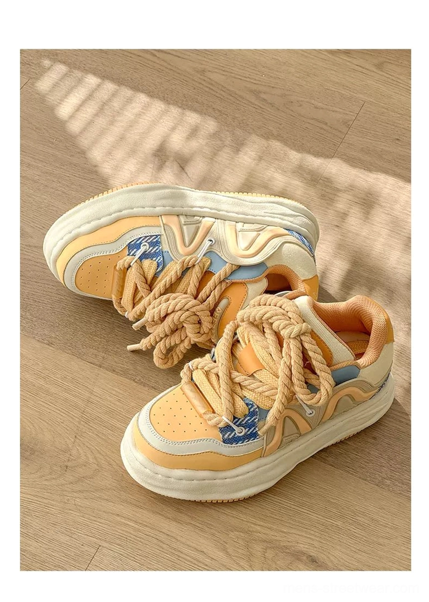 Top view of cheese yellow chunky platform sneakers with oversized rope laces on wooden floor