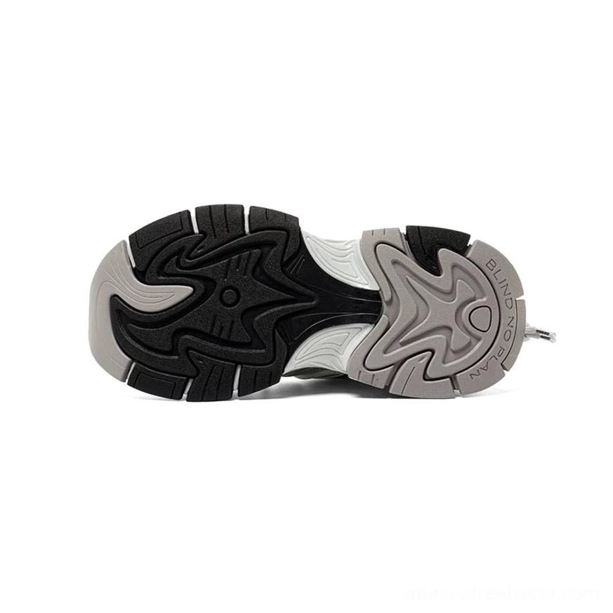 Bottom view of chunky runner sneaker outsole with black and grey rubber construction and multi-grip anti-slip tread pattern