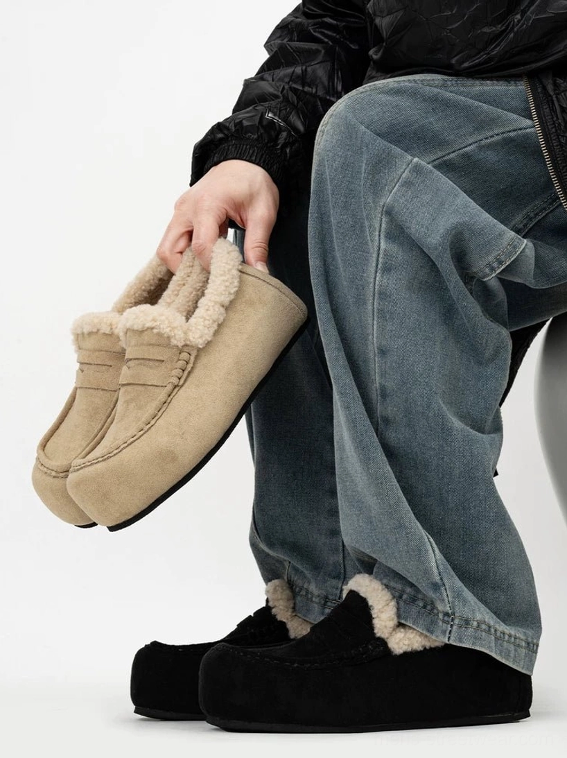 Chunky shearling lined suede penny loafers worn with baggy blue jeans in side profile streetwear styling