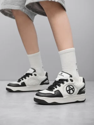 Model wearing circle logo colorblock skate sneakers grey shorts white crew socks front angle streetwear styling