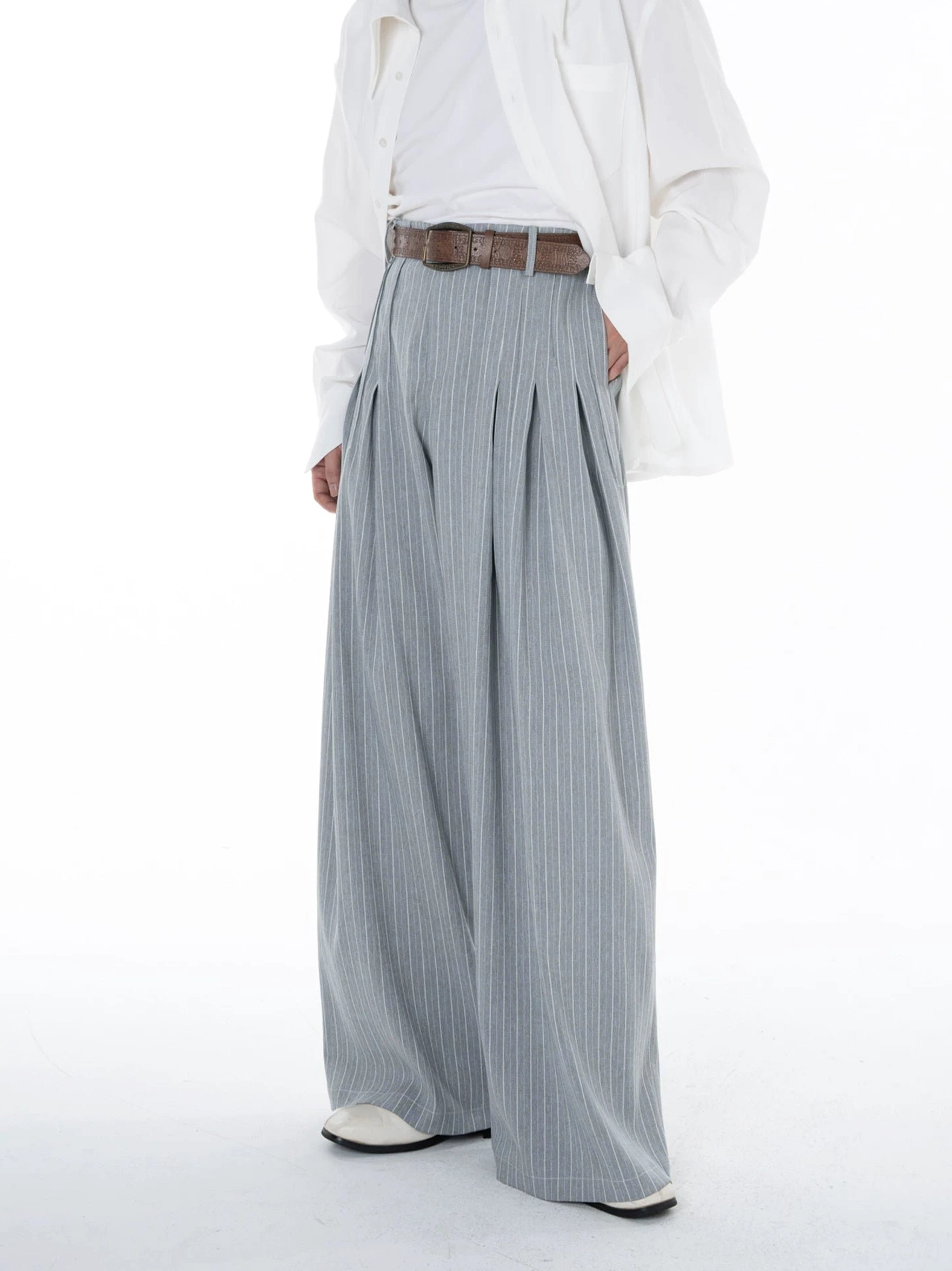 Side view of Cloudline grey pinstripe pleated ultra wide leg trousers highlighting the long fluid drape and oversized silhouette