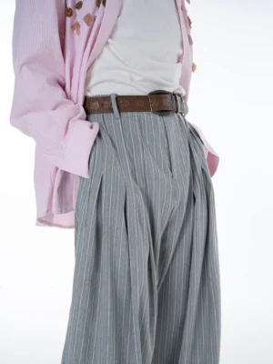 Close-up of the high waist and layered front pleats on Cloudline grey pinstripe ultra wide leg trousers