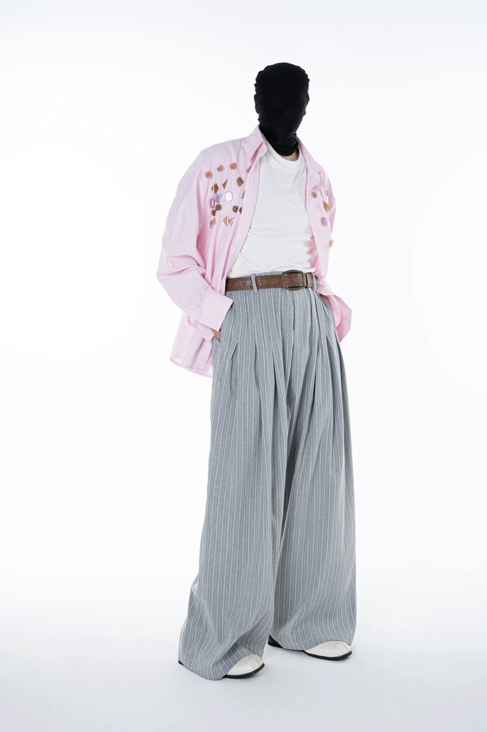 Side profile of Cloudline grey pinstripe wide leg trousers with hand in pocket showing the relaxed oversized tailoring