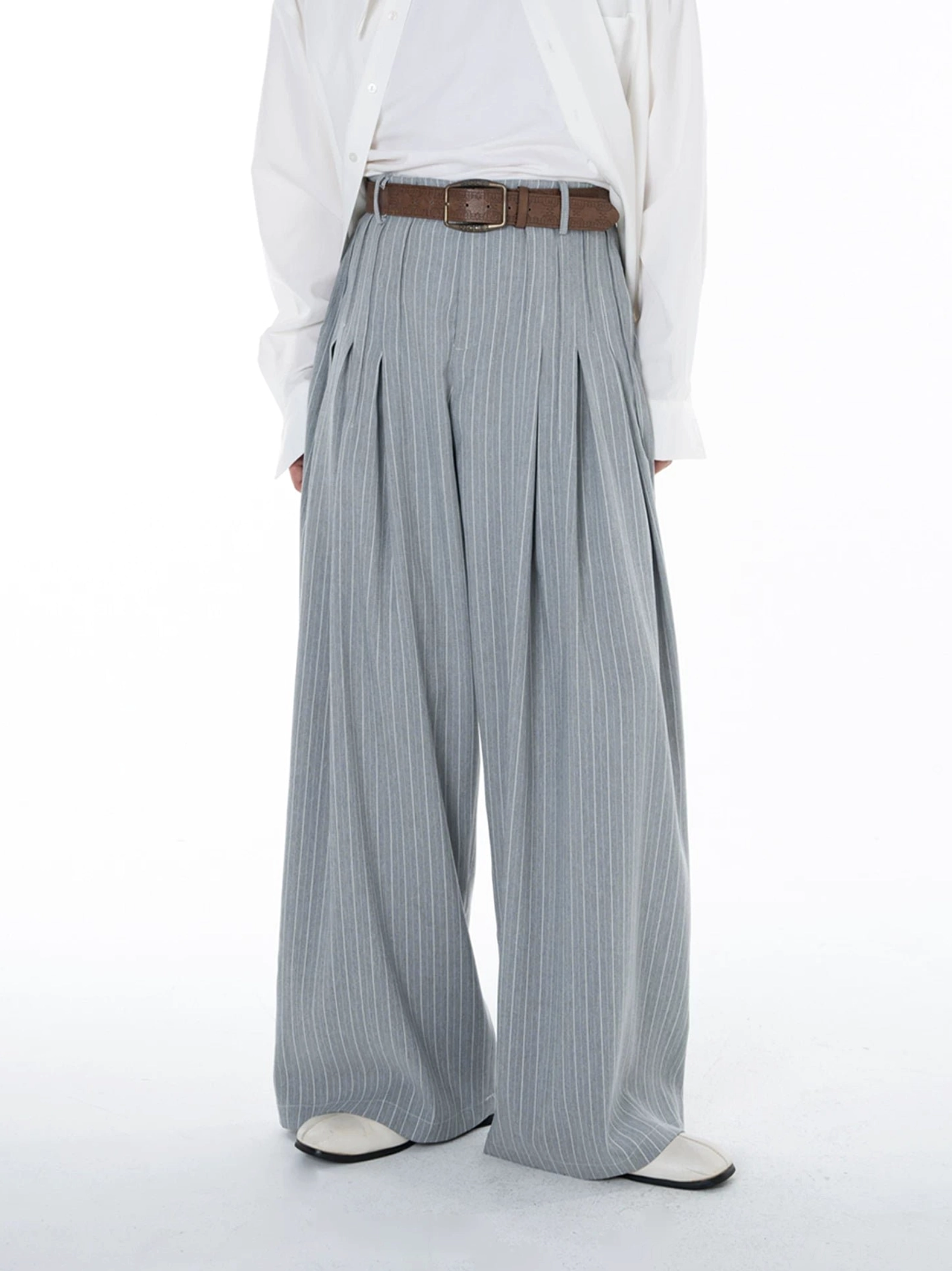 Full front view of Cloudline light grey pinstripe pleated wide leg trousers styled with a relaxed white shirt