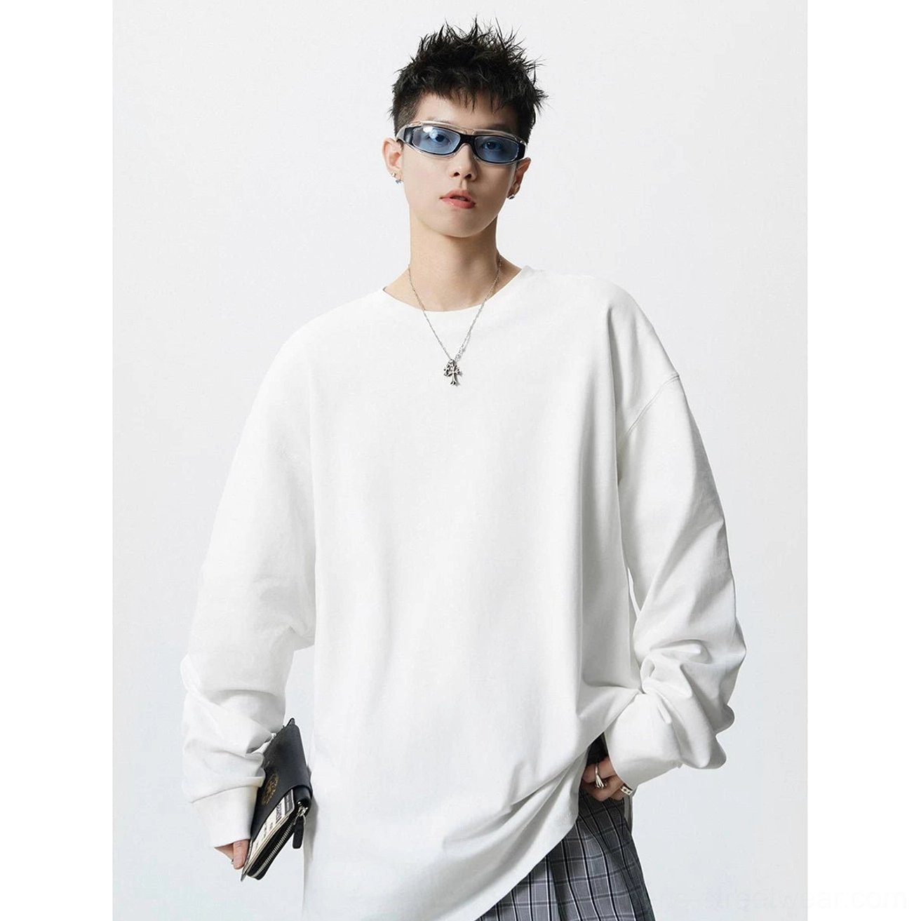 White oversized long sleeve streetwear tee shown in three quarter view with elongated hem and dropped shoulders