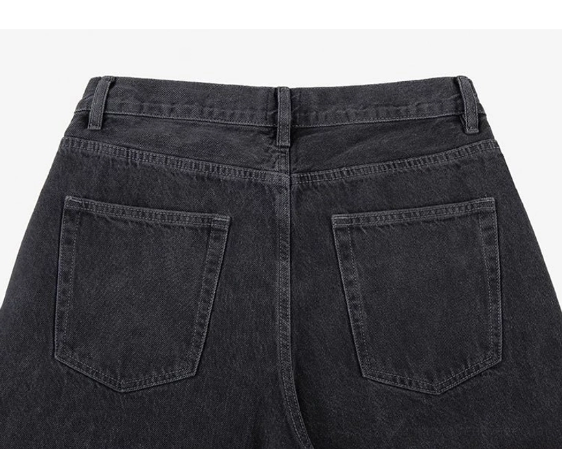 Rear waist and back pocket detail of black wide-leg jeans with stitched rectangular patch pockets and belt loops