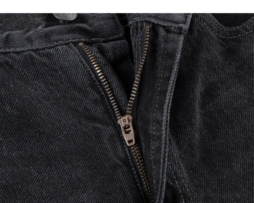 Close-up view of the heavy-duty metal zipper fly and neat seam construction on washed black wide-leg streetwear jeans