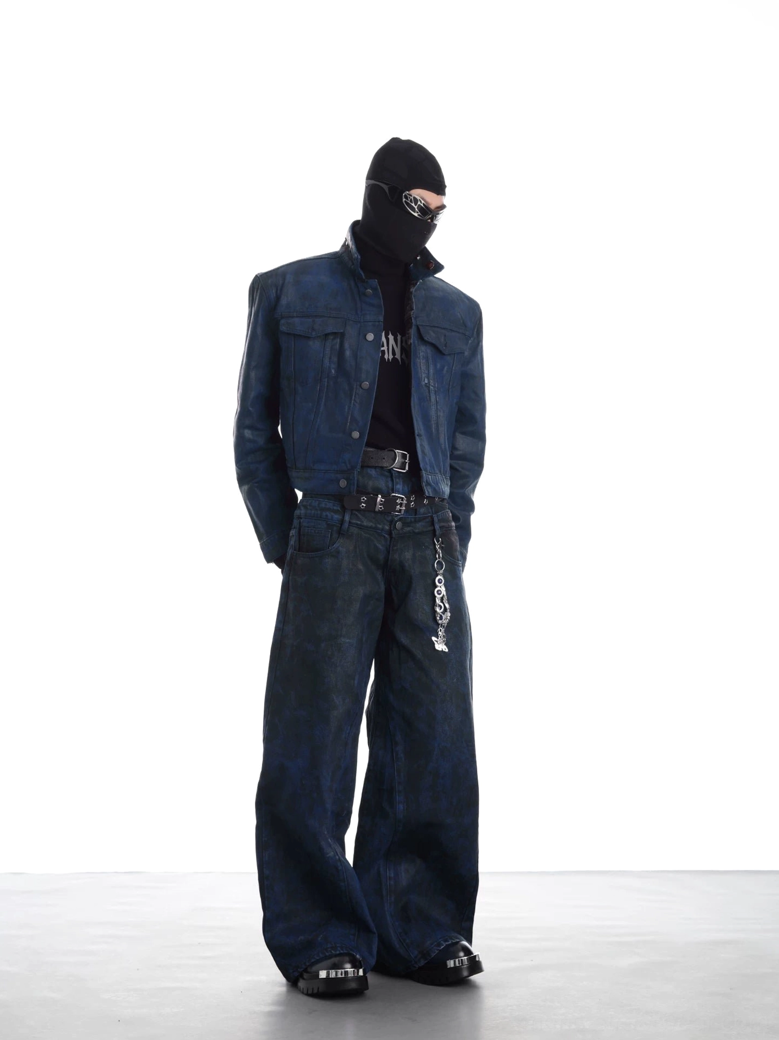 Dark cobalt blue distressed faux leather cropped trucker jacket styled with matching wide-leg trousers in a modern streetwear look