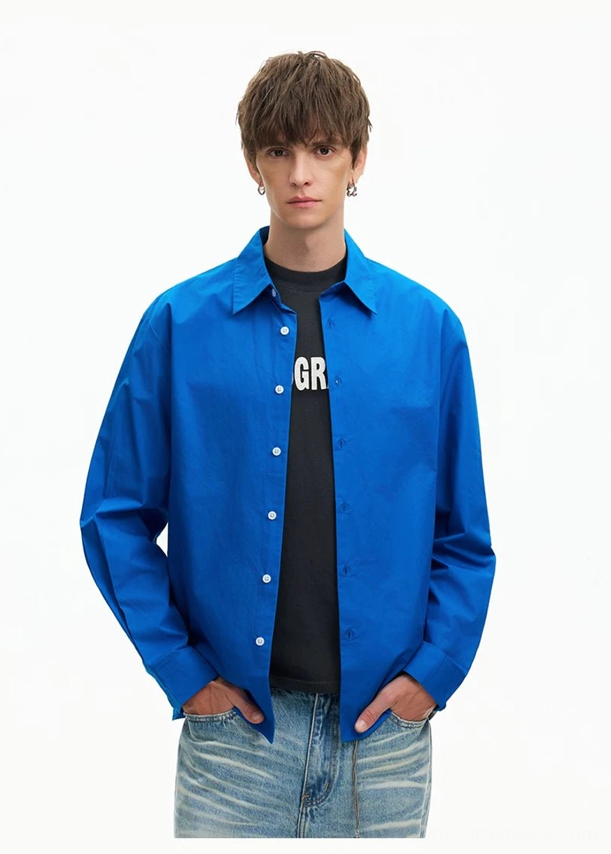 Royal Blue oversized long-sleeve shirt layered over a black graphic T-shirt with hands in pockets and relaxed streetwear styling