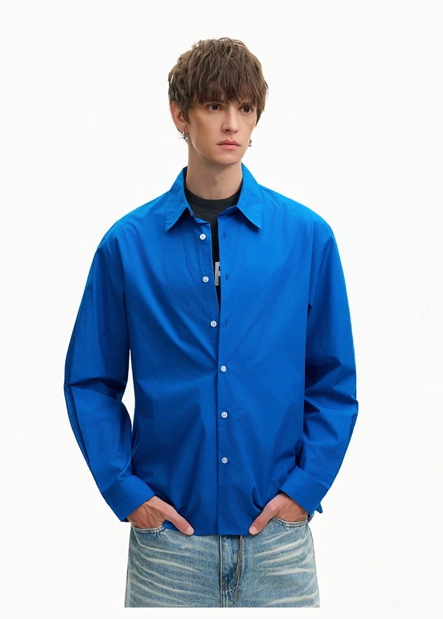 Side-angle upper-body view of a Royal Blue oversized poplin shirt with full button closure and loose Korean streetwear fit