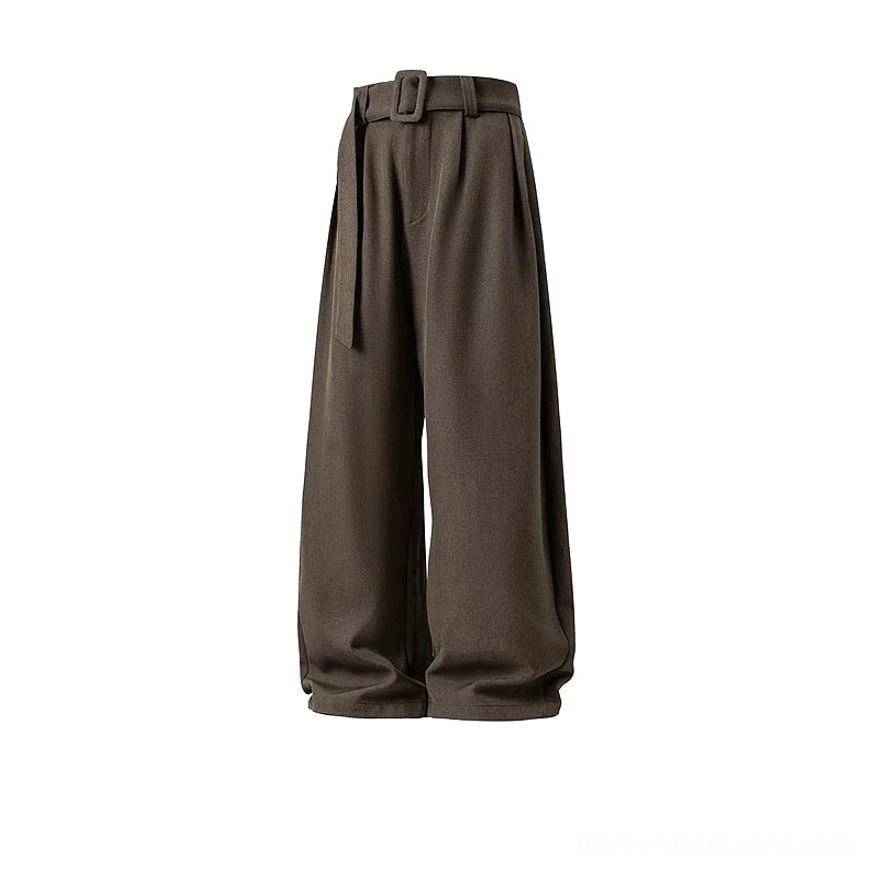 Flat product view of dark cocoa brown belted wide-leg trousers with pleated front, curved hem shape, and modern Acubi streetwear proportions