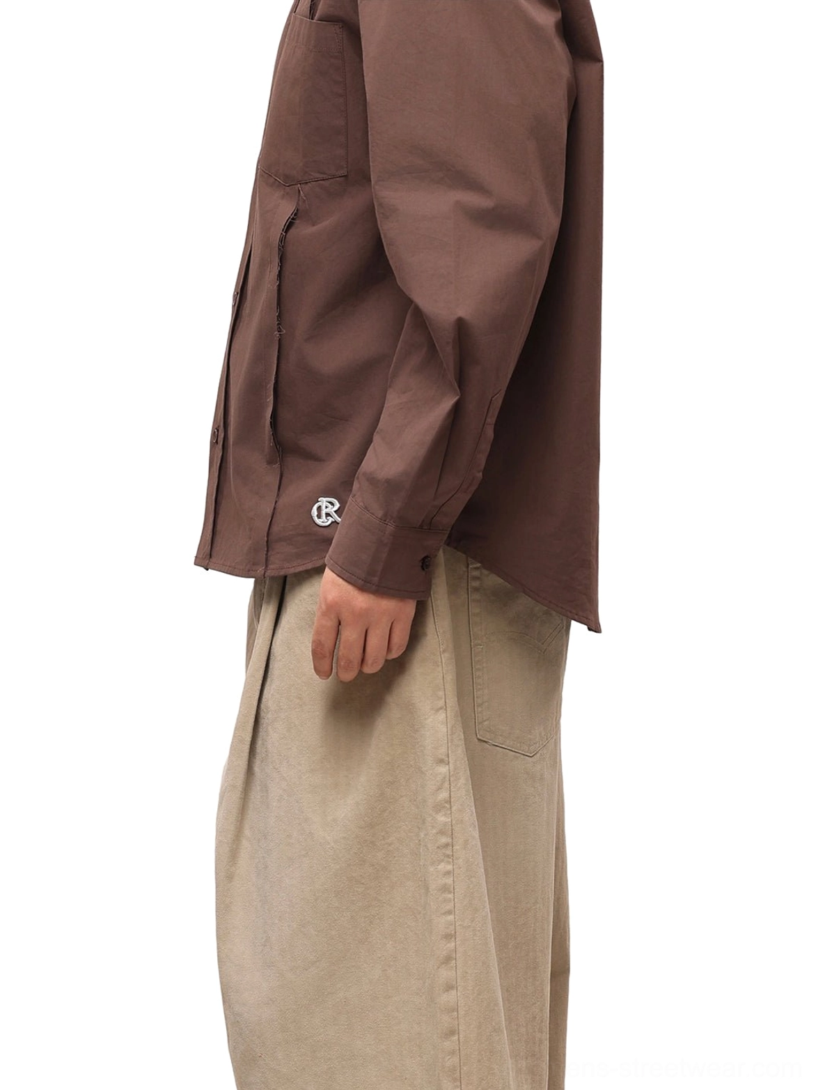 Close side view of coffee brown poplin overshirt showing curved hem subtle sleeve embroidery and tailored side seam