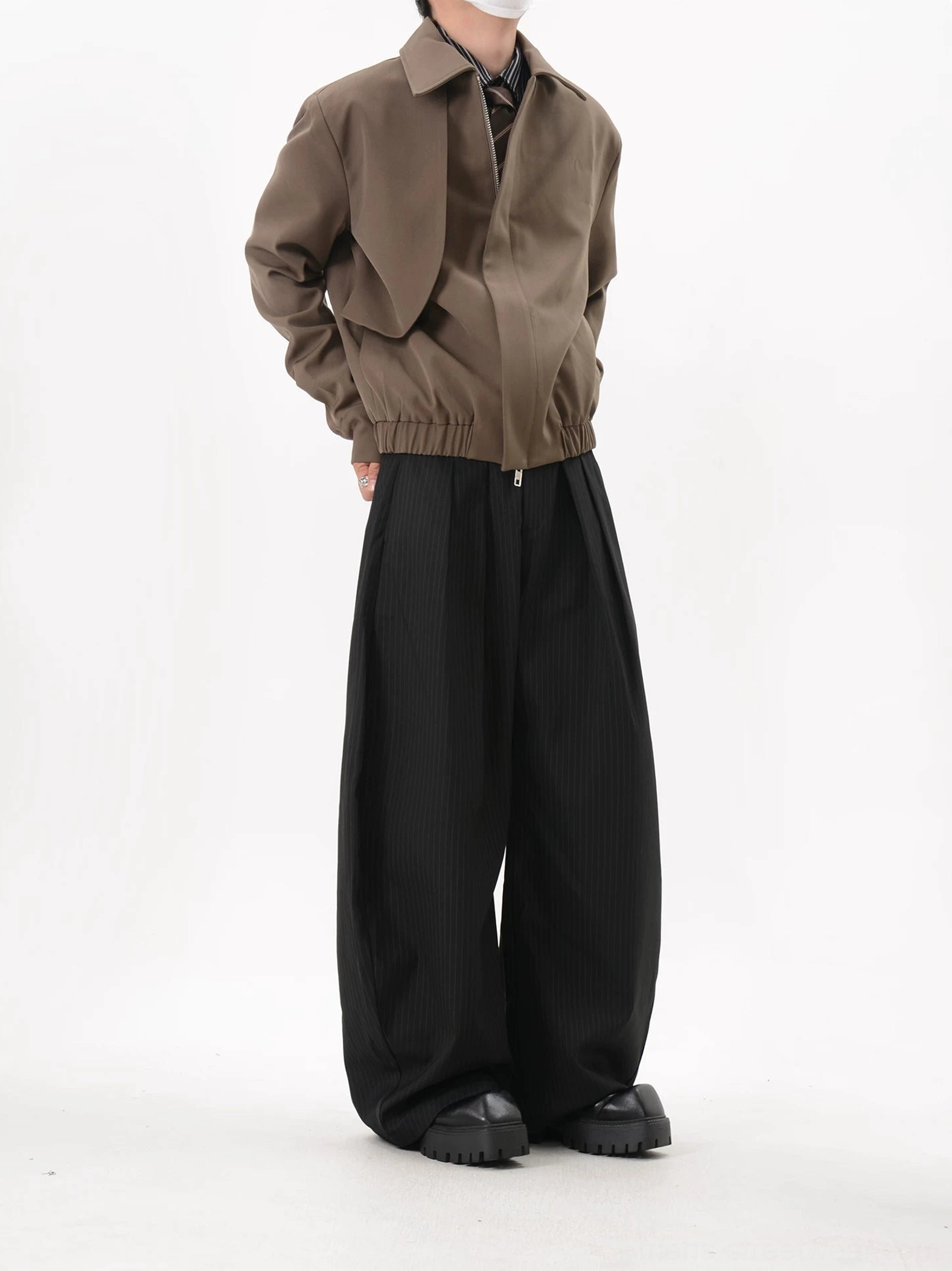 Side profile of coffee brown minimalist cropped blouson jacket with gathered hem and tailored collar