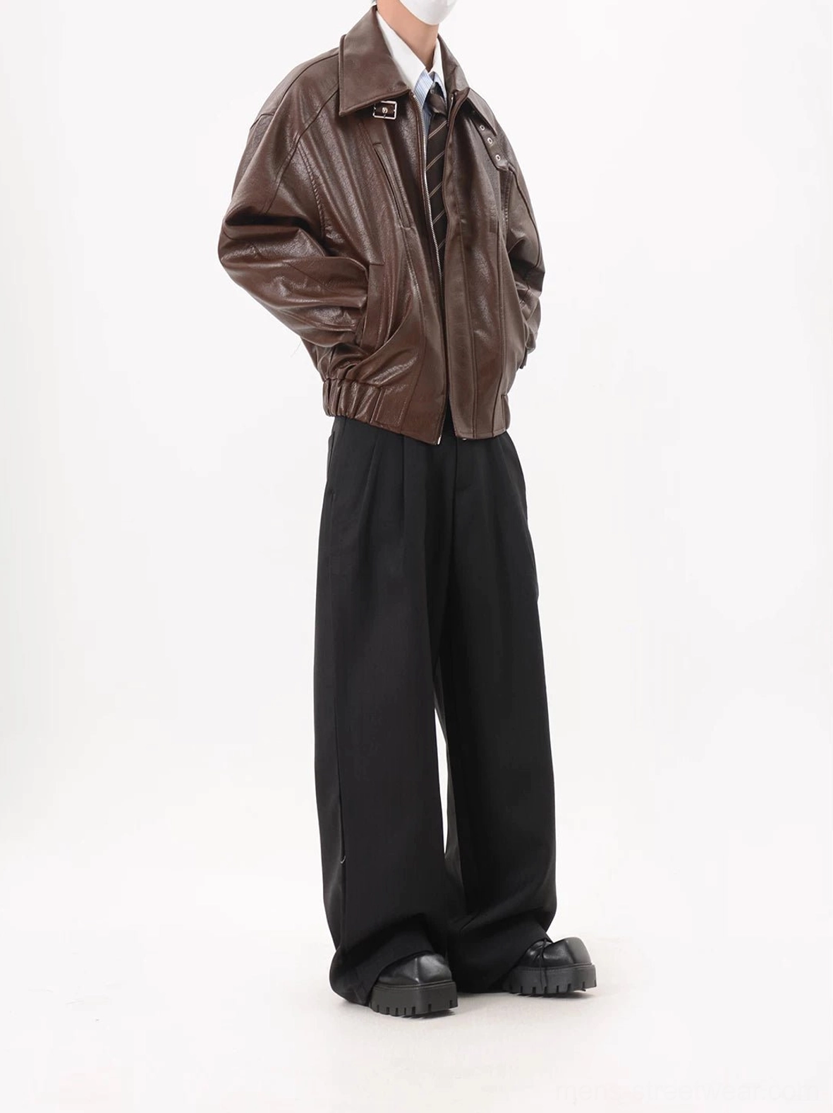 Coffee brown oversized faux leather zip-up bomber jacket right three-quarter view styled with formal shirt and wide-leg trousers