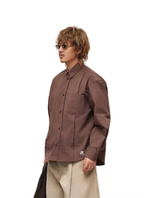 Male model wearing coffee brown relaxed poplin overshirt with beige wide-leg trousers in Korean streetwear outfit