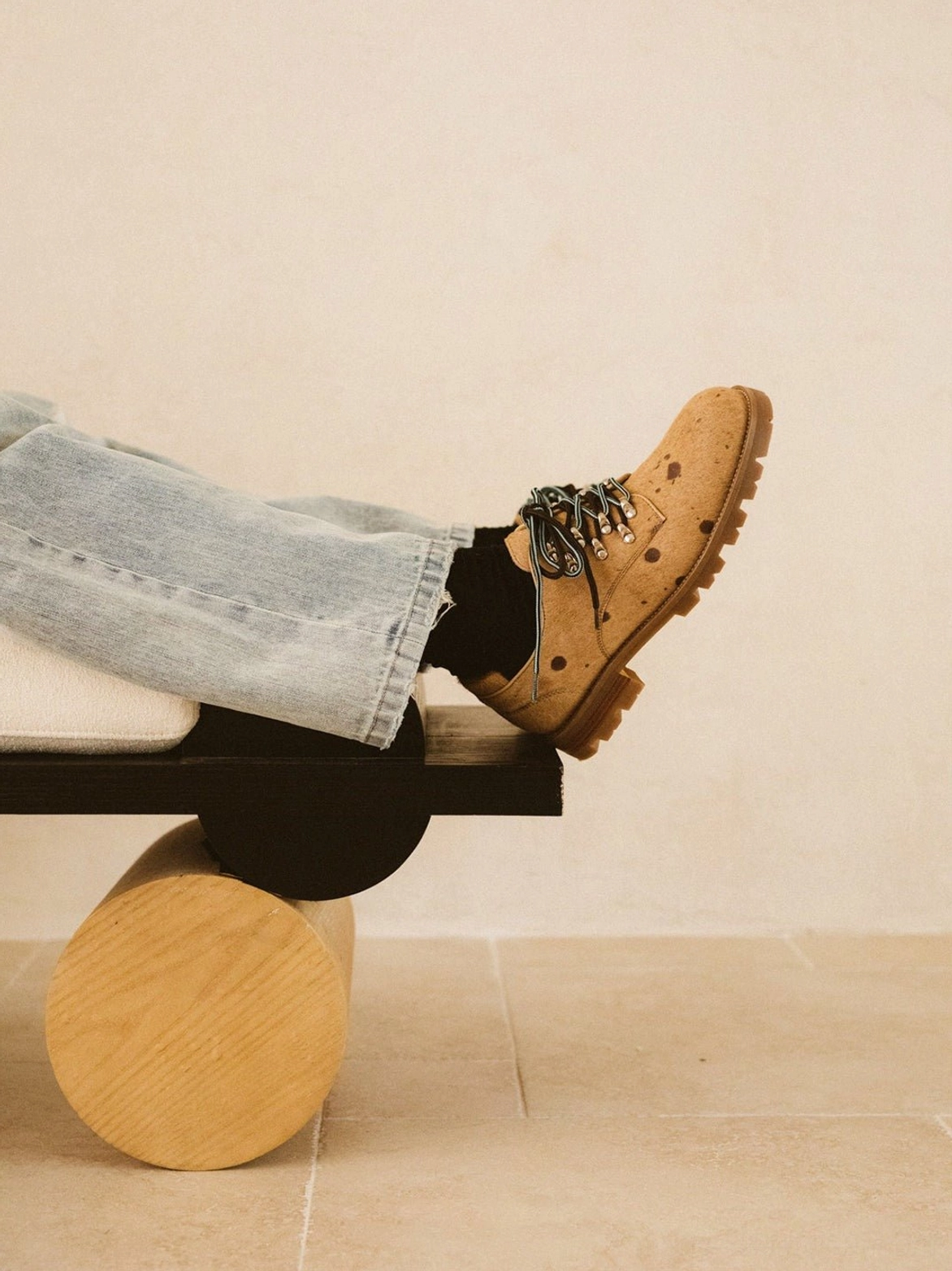 Model wearing coffee brown spotted pony-hair derby shoes with light blue jeans and black socks in a relaxed Japanese workwear-inspired outfit