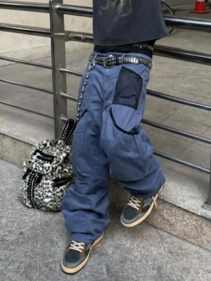 Retro star panel low-top sneakers styled with baggy blue cargo pants and a studded belt in an outdoor urban streetwear setting