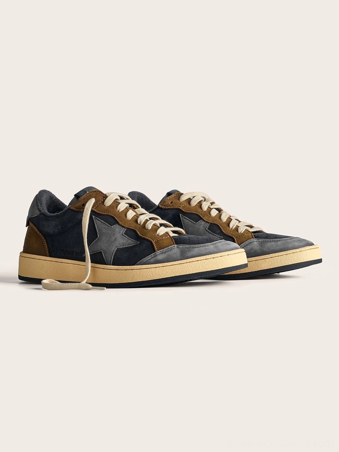 Low side profile of coffee and gray star panel retro sneakers showing the full low-top silhouette and contrasting star logos