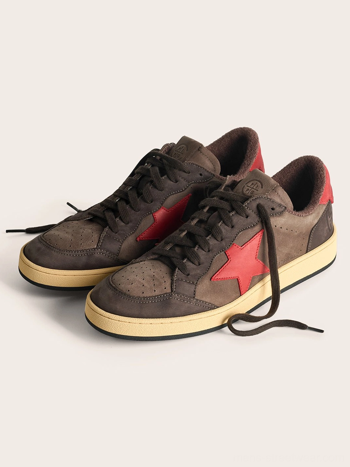 Close product view of coffee and gray star panel low-top sneakers highlighting the layered materials and retro streetwear design