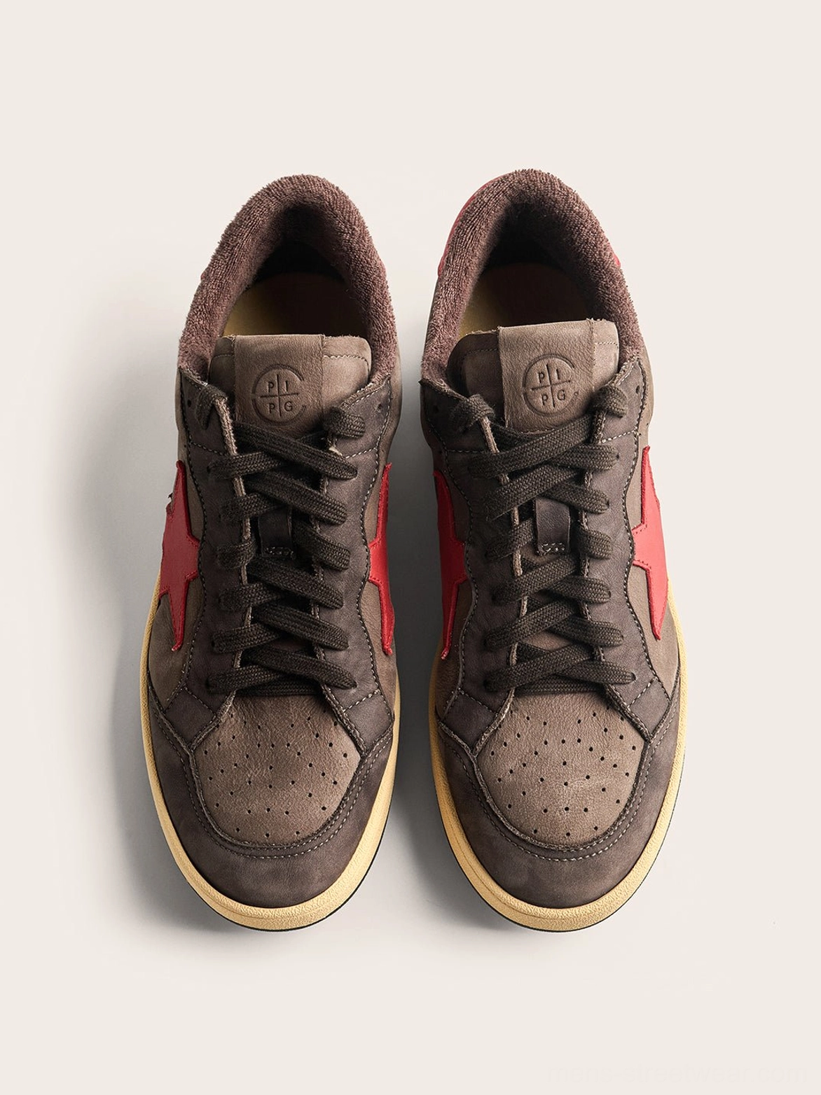 Vintage-inspired coffee gray star panel low-top sneakers with neutral color blocking and an off-white rubber outsole