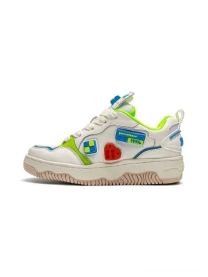 Side view of white color block building brick chunky platform skate sneaker with green blue accents and red heart detail