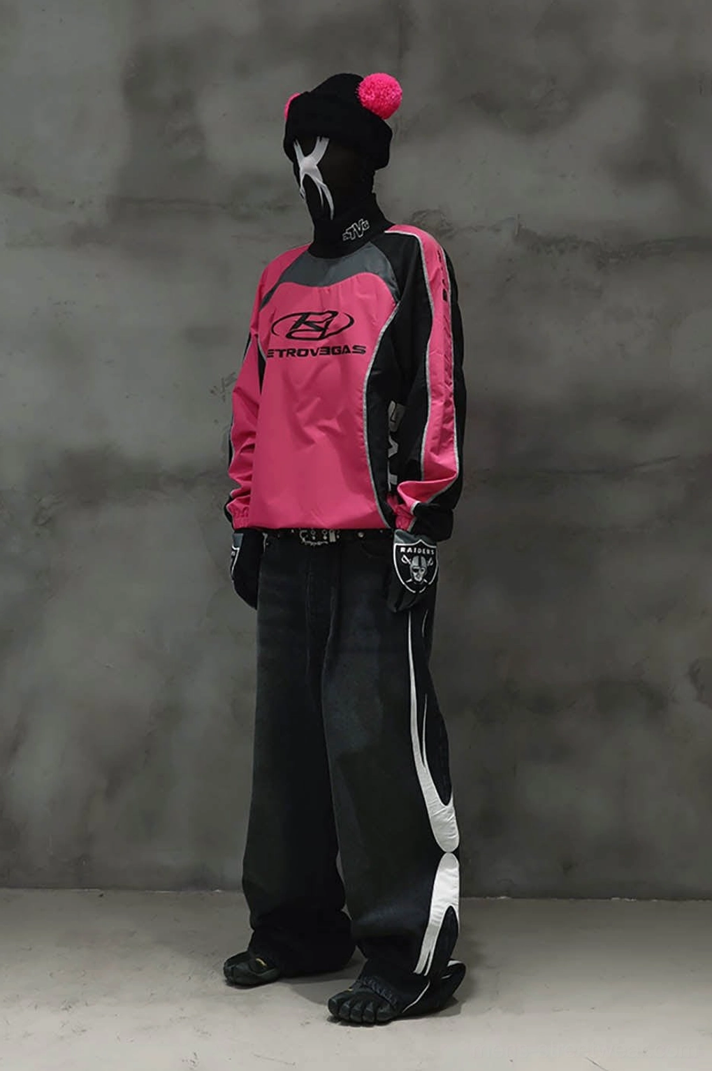 Side profile of color block racing raglan jersey with fitted long sleeves and wide-leg dark trousers