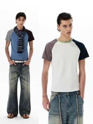 Front full body view of a color block raglan T-shirt styled with vintage wide leg denim jeans in a minimalist white studio