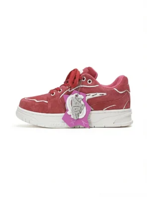 Red color-pop low-top skate sneaker in a left three-quarter view with suede-textured upper, white wing-shaped side detail, contrast stitching, and thick white rubber outsole