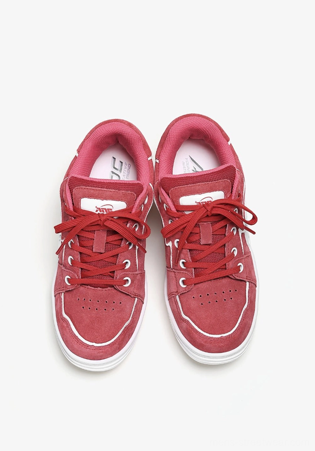 Pair of red color-pop skate sneakers in a top-down flat lay with visible tongues, laces, white outsole trim, and streetwear styling