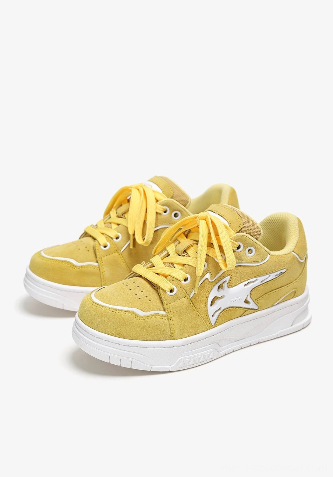 Yellow color-pop low-top skate sneaker in a stacked three-quarter product view with yellow laces, textured upper, white side detail, and chunky outsole