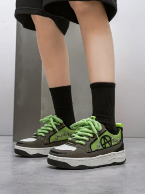 Colorblock graphic skate sneakers worn with black streetwear shorts and mid-calf socks in a minimalist concrete studio