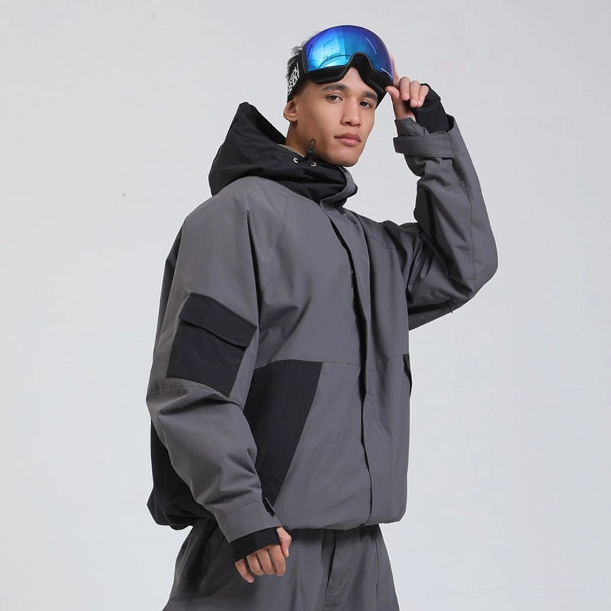 Dark grey and black colorblock snowboard shell jacket with adjustable hood and relaxed technical streetwear fit side view