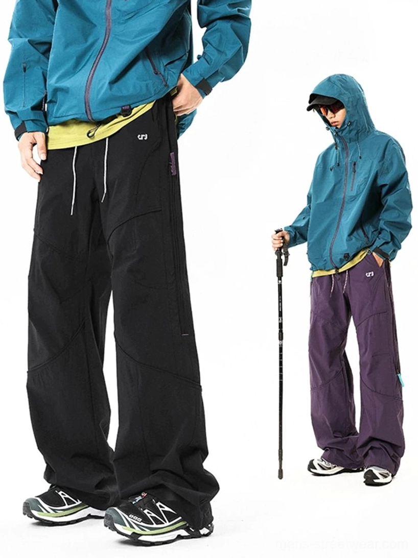 Black wide-leg tech cargo pants styled with a teal outdoor jacket and sneakers in a full front streetwear outfit
