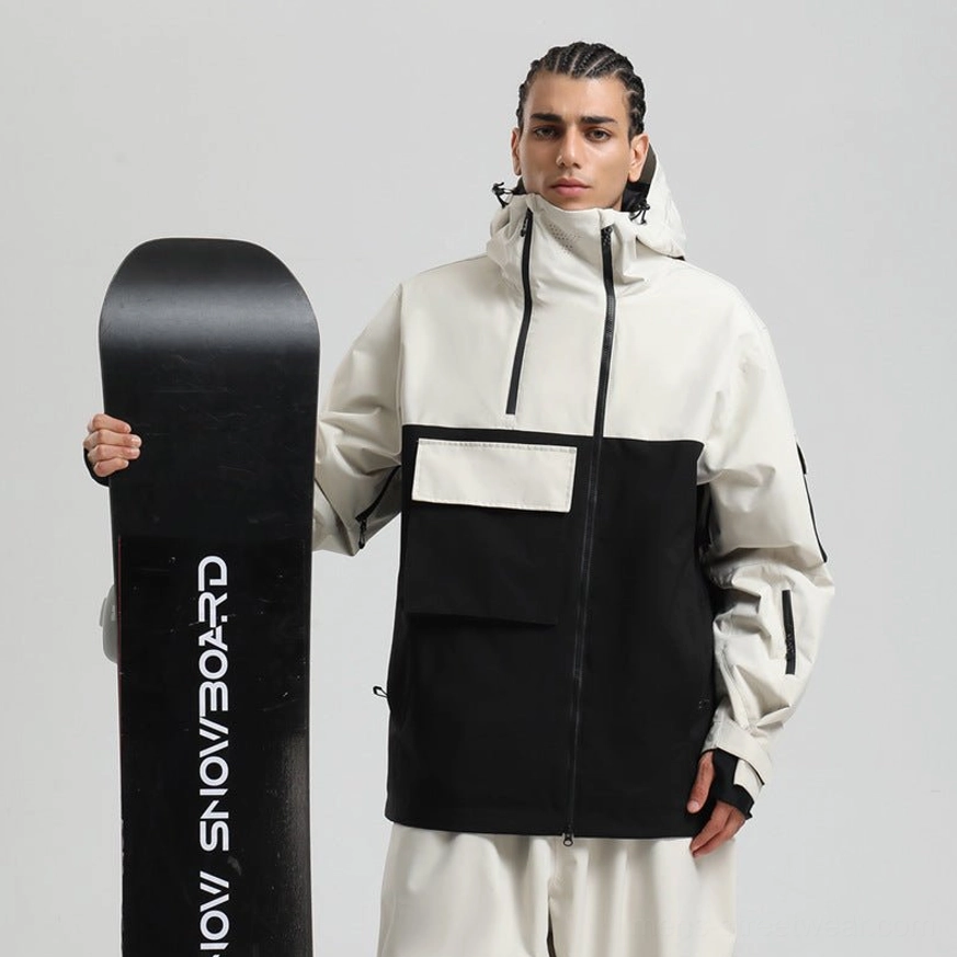 Male model wearing an off white and black colorblock techwear snowboard jacket with hood, cargo pocket, diagonal zipper, and snowboard studio styling
