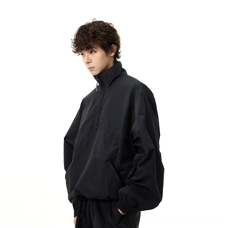 Contemporary all-black streetwear set featuring a roomy windbreaker and functional wide-leg cargo pants