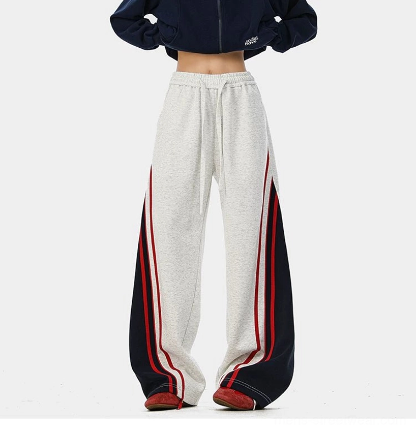 Contemporary wide-leg track pants with retro sportswear influence, contrast panels, and relaxed unisex streetwear design