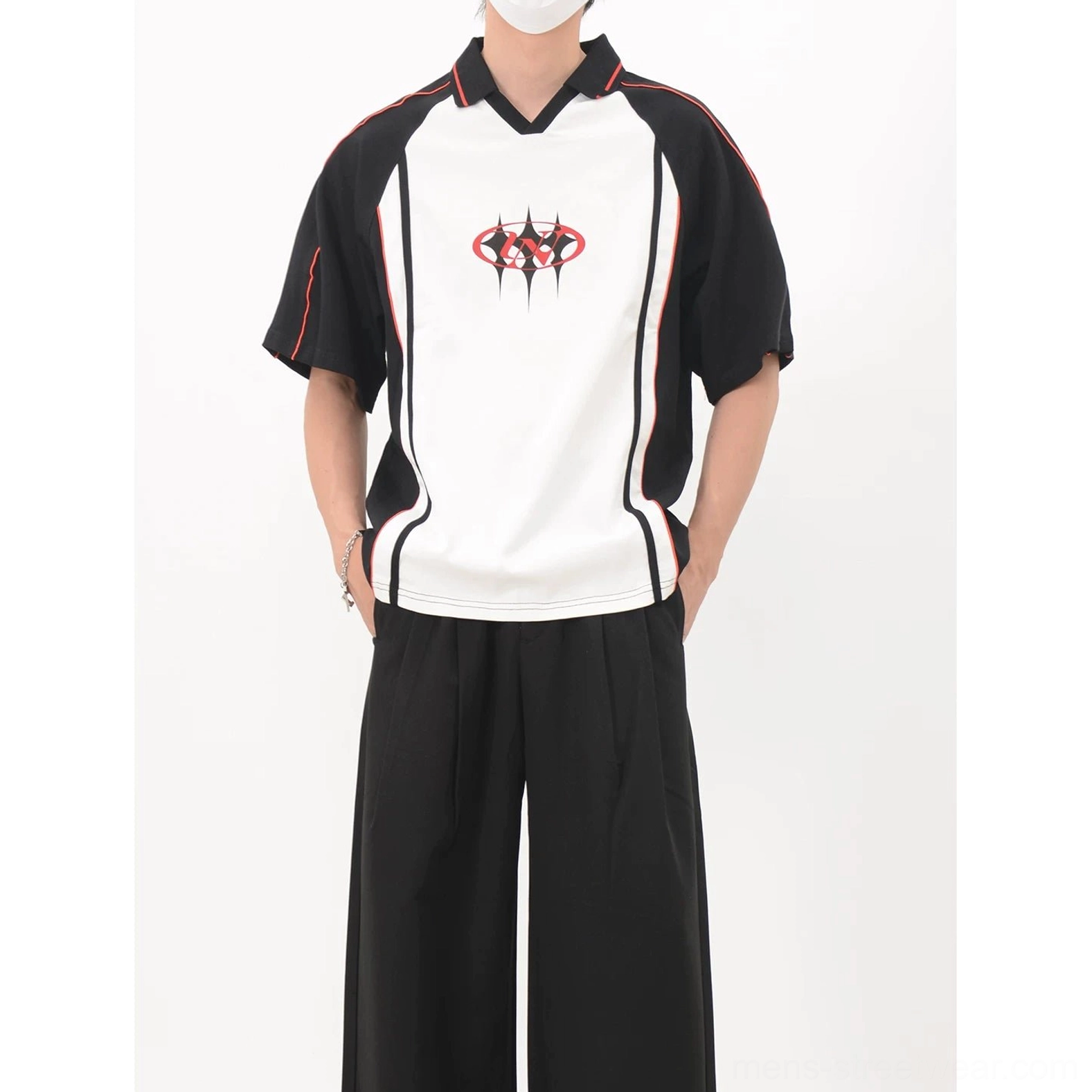 Contrast black and white soccer jersey shirt with raglan sleeves, red piping, chest crest, and wide-leg streetwear outfit