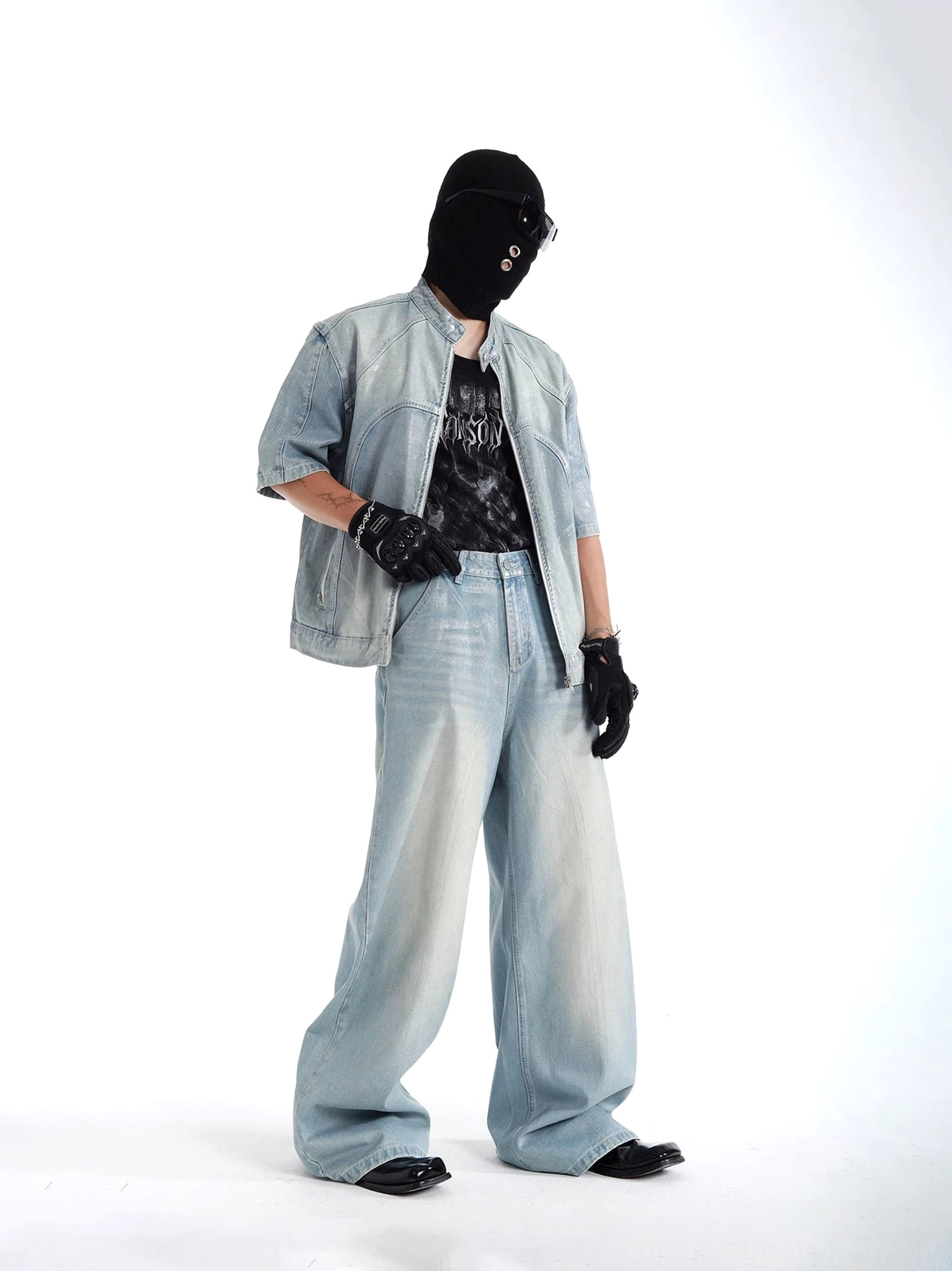 Three-quarter styling view of coordinated faded denim jacket and loose wide leg jeans with layered graphic streetwear outfit