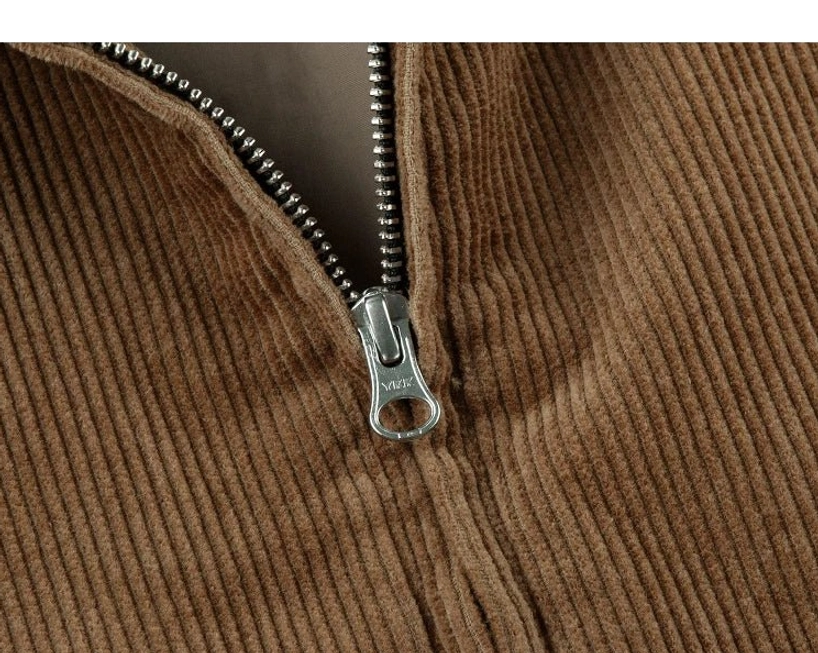 Detailed view of silver-toned metal zipper on wide-wale corduroy Harrington jacket with grey lining visible