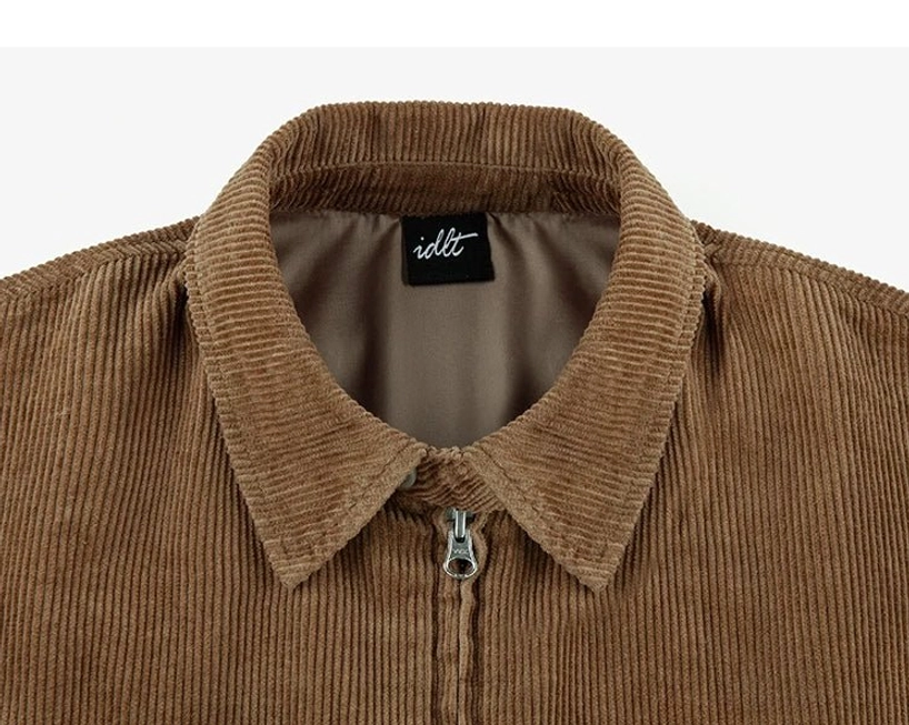 Close-up front view of corduroy Harrington jacket pointed collar woven inner label and polished metal zipper